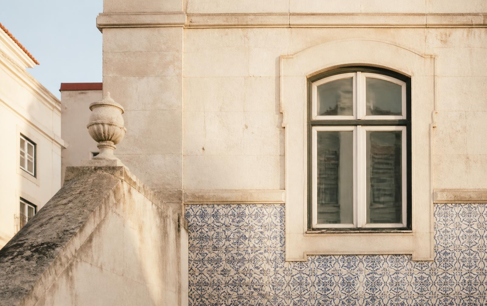 Stone facade and azulejo tiles on a Lisbon building in soft morning light